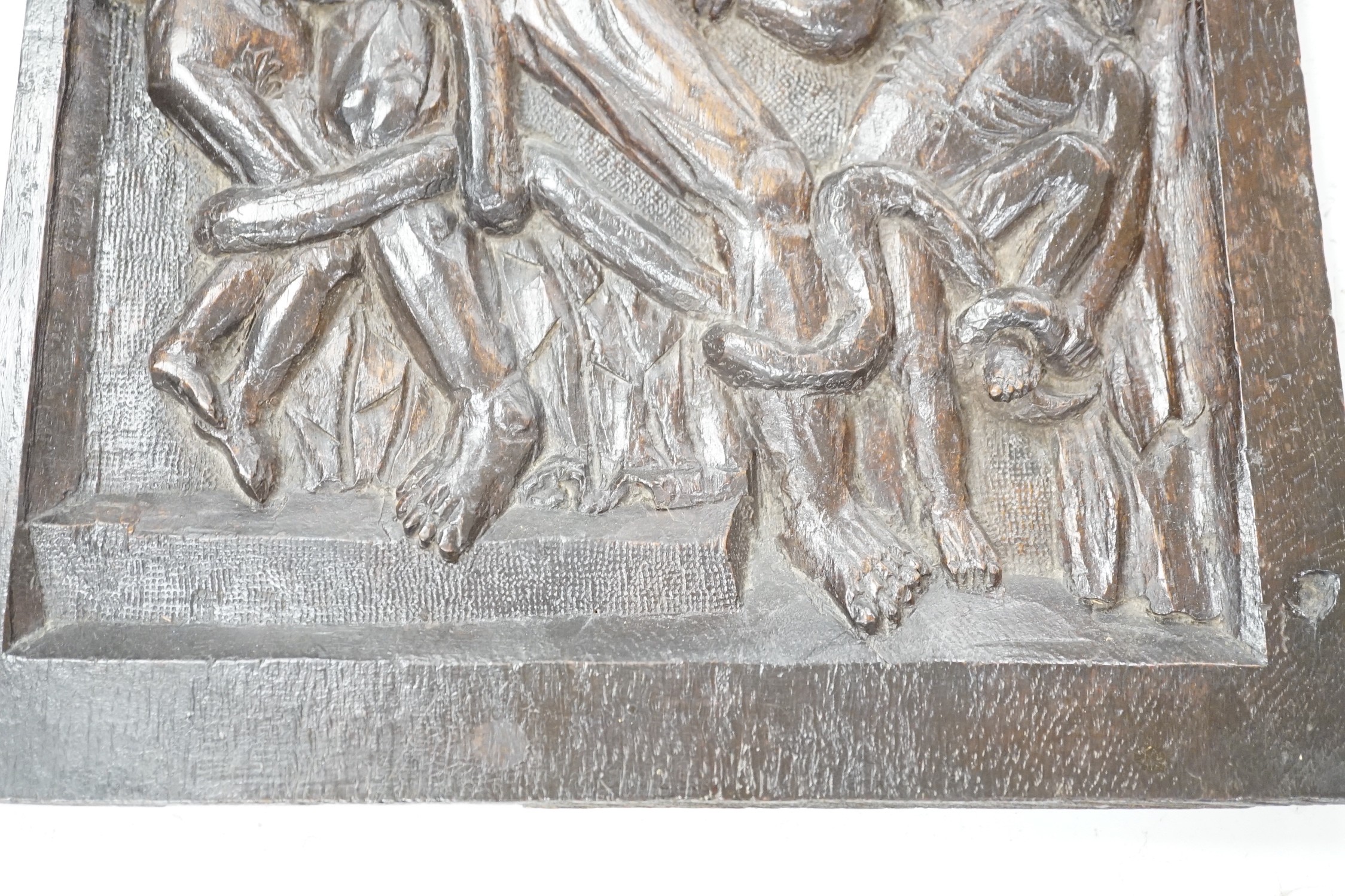 A carved oak figural panel depicting Laocoön and his son is fighting serpents, 46 x 32cm